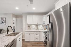 a kitchen with white cabinets and a stainless steel refrigerator at Restful Retreat - 2BDR for 6 in Kimberling City
