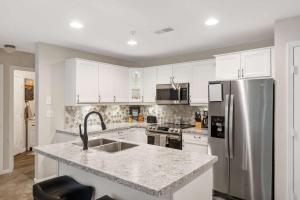 a kitchen with white cabinets and a stainless steel refrigerator at Restful Retreat - 2BDR for 6 in Kimberling City