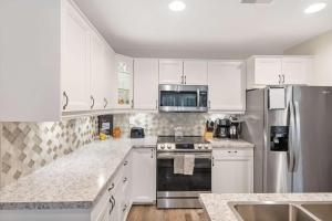 a kitchen with white cabinets and stainless steel appliances at Restful Retreat - 2BDR for 6 in Kimberling City +16 photos