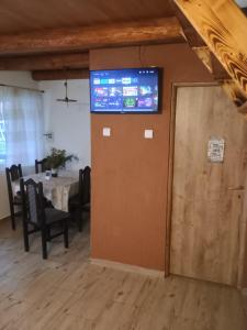 a room with a table and a television on a wall at Casa Fresh in Sântimbru-Băi