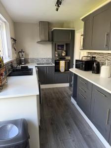 a kitchen with gray cabinets and white counter tops at Bright Private Room with Parking & Garden Access in Spennymoor