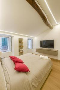 a bedroom with a large bed with red pillows at WELCOME RIVIERA- Mazzini 77 con WIFI, condizionamento in ogni stanza, parcheggio a pagamento 15euro al giorno da prenotare in anticipo in Rapallo