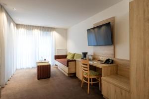 a hotel room with a desk and a bed at Hotel Rössle Berneck in Altensteig