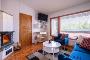 ein Wohnzimmer mit einer blauen Couch und einem Kamin in der Unterkunft Rukariutta Apartments in Ruka