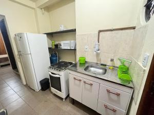 a small kitchen with a sink and a refrigerator at Apartamento em prédio familiar in Petrópolis +13 photos