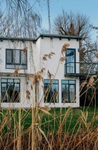 a white house with blue windows and grass at Im Scheunhornweg in Werder