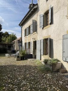a building with a patio and an umbrella at Domaine à la Loëx in Geneva
