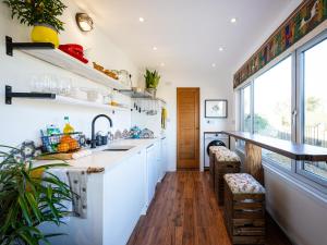 a kitchen with white cabinets and a counter and a window at Sunrise Cabin in East Ilsley