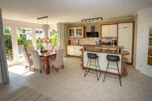 una cucina e una sala da pranzo con tavolo e sedie di Reethaus StrandZeit in Lobbe - Haushälfte 2 a Lobbe