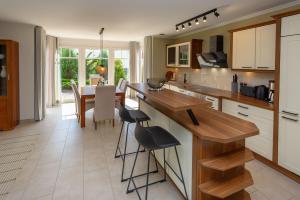 una cucina con un bancone e un tavolo con sedie di Reethaus StrandZeit in Lobbe - Haushälfte 2 a Lobbe