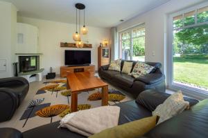 un soggiorno con un divano e un tavolo di Reethaus StrandZeit in Lobbe - Haushälfte 2 a Lobbe Altre 29 foto