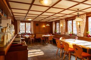a dining room with tables and chairs and windows at Hotel Rössle Berneck in Altensteig
