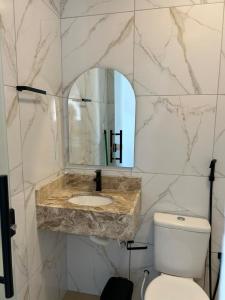 Un baño con lavabo, inodoro y espejo. en Pousada Bella Flor, en Baía Formosa 86 fotos más