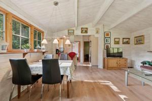 KølkærにあるHyggeligt Sommerhus Nær Herningのテーブルと椅子のあるダイニングルーム
