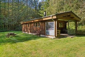 KølkærにあるHyggeligt Sommerhus Nær Herningのピクニックテーブルとベンチのある野原の木造小屋 +8枚の写真
