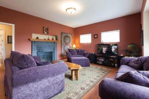 a living room with purple furniture and a fireplace at Daisy's Place 30 day minimum in Hood River