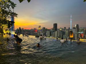 a group of people in a swimming pool with a city skyline at Axon Residence KL in Kuala Lumpur