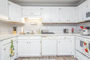 eine weiße Küche mit weißen Schränken und einer Spüle in der Unterkunft No Place Like Homeplace Ii in Fayetteville