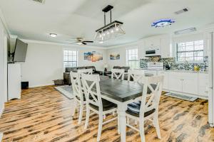 a kitchen and dining room with a wooden table and chairs at Ultimate Canal Front Game Room Boat Ramp in Crystal Beach