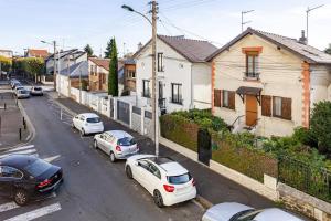 un grupo de coches estacionados en una calle con casas en Élégance & confort - aux portes de Paris, en Aulnay-sous-Bois