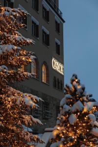 a building with a christmas tree in front of it at Hotel GRACE LA MARGNA ST MORITZ in St. Moritz