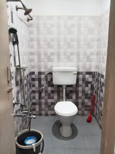 Un baño con un inodoro blanco en una habitación. en Pacio Residency, en Kanchipuram