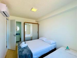 ein Hotelzimmer mit zwei Betten und einem Spiegel in der Unterkunft MyPlace Benfica By Holiday Stays in Fortaleza