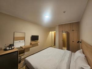 カイロにあるOasis Heliopolis Hotel-فندق أوازيس هليوبوليسのベッドとテレビ付きの机のある寝室 +17枚の写真