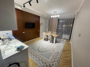 Una cocina y un comedor con mesa y sillas. en ЖК Керуен Сарай, en Türkistan