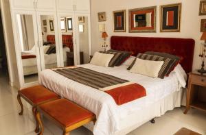 サン・ミゲル・デル・モンテにあるPosada Suiza by Prima Collectionの赤いヘッドボードが付いた大きなベッドのある寝室 +58枚の写真