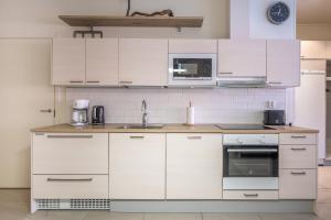 a kitchen with white cabinets and a sink at Rukariutta Apartments in Ruka +28 photos