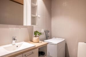 a white bathroom with a sink and a toilet at Rukariutta Apartments in Ruka