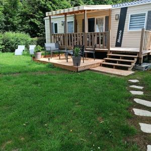 a house with a wooden deck with a bench and stairs at Les Ch'tis Normands 2! in Litteau