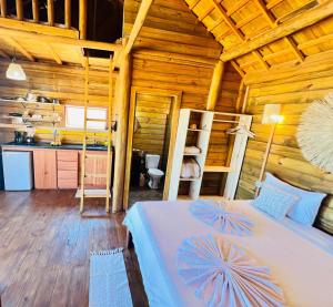 a bedroom with a bed in a wooden cabin at Chalet Paraiso Canoa 3 na praia - Canoa Quebrada in Aracati