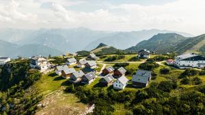 a village on a hill with mountains in the background at Chalets am Feuerkogel by Landluft in Ebensee