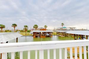 Patton WoodsにあるPrime Canal Front w/ Dock Outdoor Kitchenの建物のある水域の隣にある白いフェンス