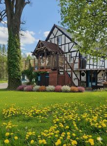 une maison avec un champ de fleurs devant elle dans l'établissement The Old Barn ZIMOWY HIT Jacuzzi Piecyk Butikowy Dom 2 Noce minimum, à Płóczki Górne