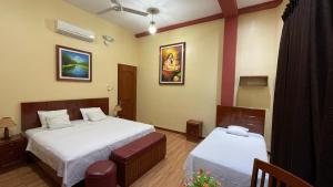 a bedroom with two beds and two tables in it at Alojamiento El Cardenal in Iquitos +51 photos