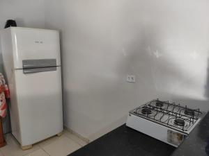 a kitchen with a stove and a white refrigerator at Residência Europa in Cacoal