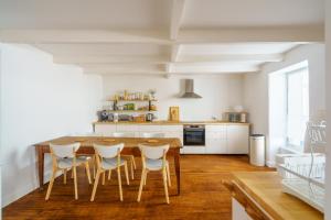 Una cocina con una mesa y sillas de madera. en Ty Beg-Hir - 10min à pied du Port, en Tréboul 7 fotos más