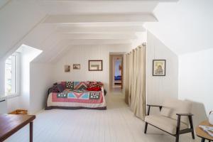 Un dormitorio con una cama y una silla en una habitación. en Ty Beg-Hir - 10min à pied du Port, en Tréboul
