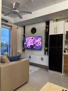 a living room with a couch and a tv on a wall at Convenient Davao Getaway in Davao City