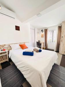 a bedroom with a large white bed with orange pillows at The Rustic Residence - Fine Culinary Experience - TRR6 in Pointe aux Canonniers