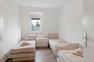 a small room with two beds and a window at Az-Living Feudenheim in Feudenheim