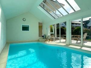 a swimming pool in a house with a glass ceiling at Villa du Rocher in Sibiril
