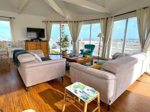 a living room with two couches and a table at Villa du Rocher in Sibiril