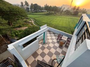 un balcón de una casa con vistas a un campo en Cocogreen Hampi, en Hampi 51 fotos más