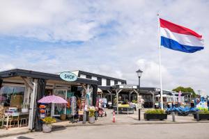 Vor einem Geschäft weht eine Flagge. in der Unterkunft Chalet 87 in Petten