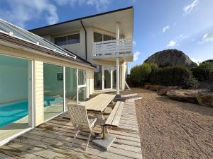 a house with a wooden deck with a table and chairs at Villa du Rocher in Sibiril