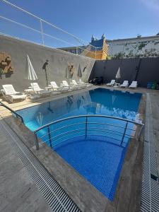une grande piscine avec des chaises longues dans l'établissement Hotel Alanya, à Alanya